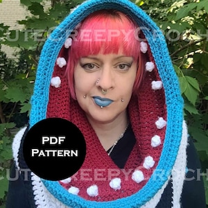 May include: A crocheted hood in red, white, black, and blue. The hood has a blue trim and white decorative accents. The text "PDF PATTERN" is in a black circle. The words "CUTE CREEPY CROCHET" are in the background.