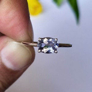 May include: A silver ring with a light blue oval gemstone.