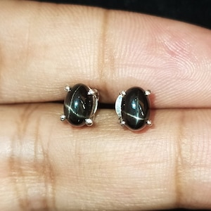 May include: A pair of silver stud earrings with black star-shaped gemstones.
