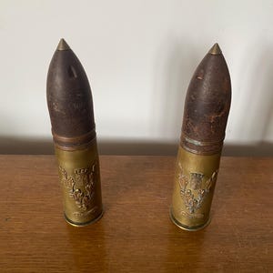 May include: Two antique brass and wood shell casings with a thistle design and the text "Edinburgh" on the side.