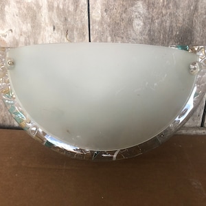 May include: A half-round frosted glass wall sconce with a silver and green mosaic trim.