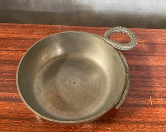 Peut inclure: Un petit plat en métal argenté avec une poignée en forme de serpent. Le plat est rond et peu profond, et la poignée est enroulée autour du bord du plat.