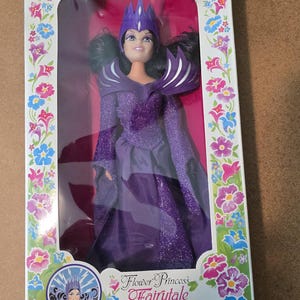 May include: A boxed Flower Princess Fairytale Witch Tempestia doll. The doll, approximately 29 cm tall, is dressed in purple and wears a crown. The box features floral patterns and the text "The Spellbinding Magical Mystery Queen."