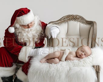 May include: Santa Claus wearing a red velvet suit with white trim and a white beard is sitting next to a white armchair. A baby is sleeping on a white fur throw in the armchair. The baby is wearing a white headband and a white crocheted wrap.