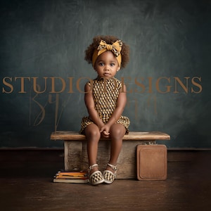 May include: A young child wearing a patterned dress and headband sits on a wooden bench. A brown leather briefcase and a stack of books and pencils are placed nearby. The background features the text "STUDIO DESIGNS".