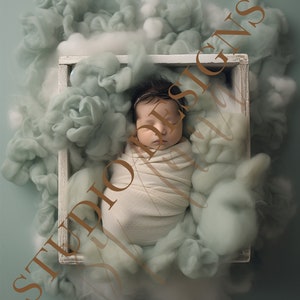 Puede incluir: Un bebé recién nacido duerme en una caja de madera blanca llena de material esponjoso de color verde claro y blanco. El bebé está envuelto en una manta blanca.