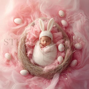 May include: A newborn baby wearing a white bunny hat sleeps in a nest of pink tulle and straw.  The nest is surrounded by white speckled Easter eggs.