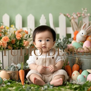 May include: A baby wearing a beige dungaree outfit sits in front of a white picket fence with a basket of Easter eggs and a bunny rabbit. The baby is surrounded by green grass, flowers, and carrots.