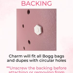 K&ouml;nnte beinhalten: Nahaufnahme einer rosa Oberfl&auml;che mit einer wei&szlig;en, sechseckigen Charm-R&uuml;ckseite. Der Text "CHARM HAS A SNUG BACKING" steht oben. Der Text "Charm will fit all Bogg bags and dupes with circular holes" steht darunter.