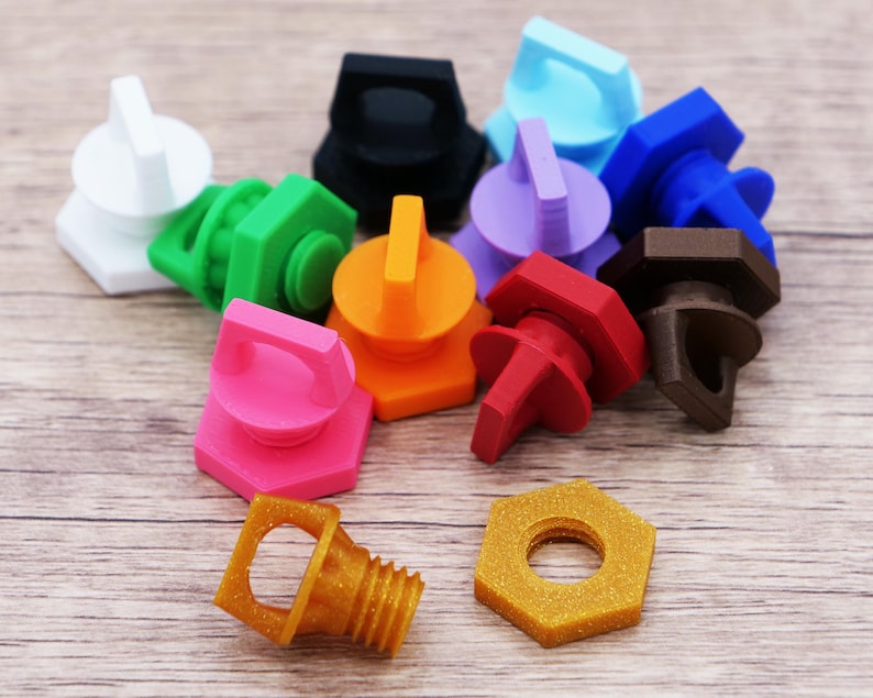 K&ouml;nnte beinhalten: Eine Sammlung farbenfroher, 3D-gedruckter Flaschenverschl&uuml;sse und eine sechseckige Mutter. Die Verschl&uuml;sse sind in verschiedenen Farben erh&auml;ltlich, darunter Wei&szlig;, Schwarz, Gr&uuml;n, Orange, Pink, Rot, Braun, Gold, Lila und Blau. Die Verschl&uuml;sse haben einen Griff zum einfachen Entfernen.