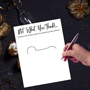 May include: A white sheet of paper with the text "Not What You Think!" and a line drawing of a shape. A hand holding a silver pen is drawing on the paper. The background is black with gold decorations.