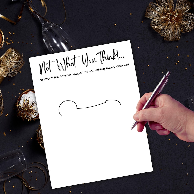 May include: A white sheet of paper with the text "Not What You Think!" and a line drawing of a shape. A hand holding a silver pen is drawing on the paper. The background is black with gold decorations.