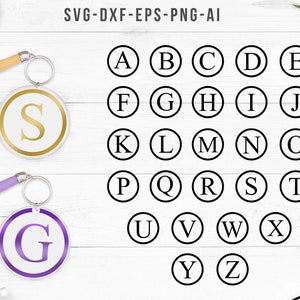 May include: A set of 26 alphabet letter keychains. Each keychain is a round, white circle with a black outline and a single letter in the center. The letters are in uppercase and are in a simple, sans-serif font. The keychains are shown on a white wooden background.