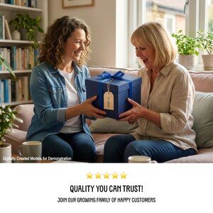 Two women sitting on a couch, one holding a blue gift box with a ribbon, smiling and laughing together.