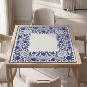 a square table with a blue and white floral patterned tablecloth, surrounded by four chairs.