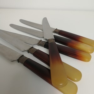 Set of 6 small old knives with cow horn handle circa 1920. Very nice art deco drawing on the metal part. Stainless steel blade