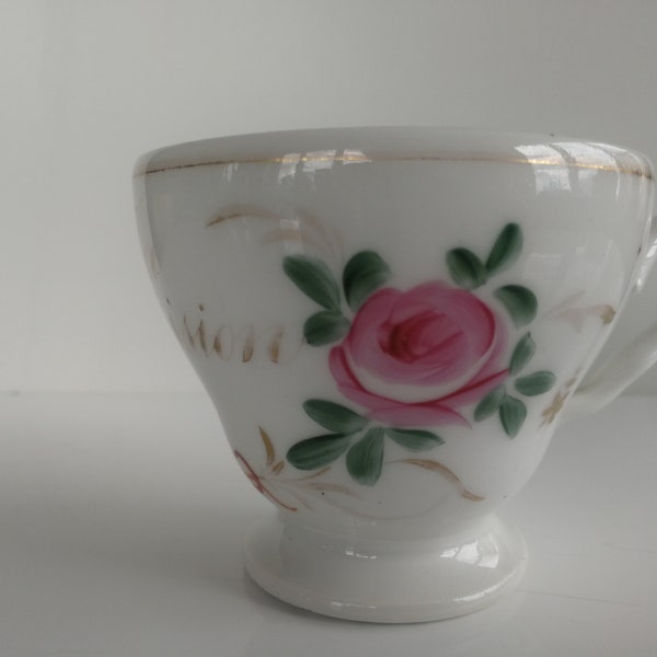Pretty old oval porcelain cup, hand painted: pink, foliage, lace, knot. Original gilded inscription; In possession. Golden border