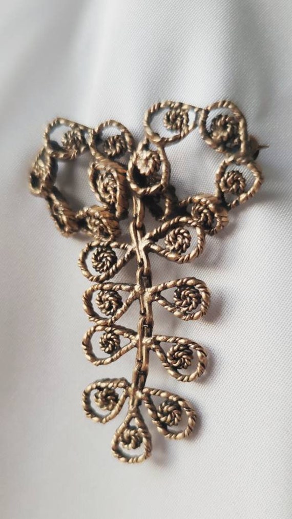 Broche en forme de noeud avec pendant articulé, co