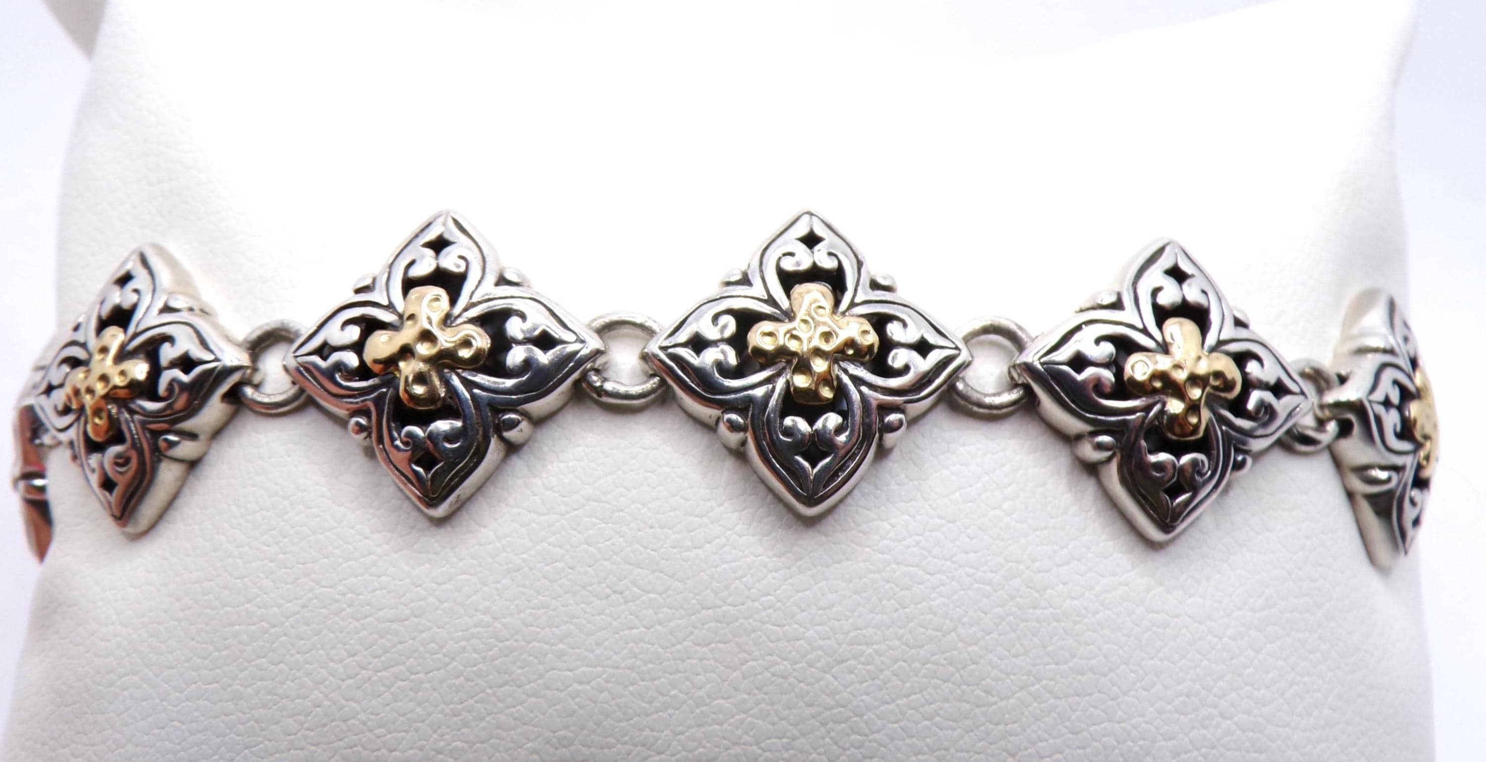 Pulsera de eslabones ornamentados con cierre de palanca, elaborada en plata de ley y oro amarillo de 18 quilates.