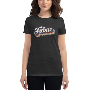 Puede incluir: Una camiseta de mujer de color gris oscuro jaspeado con un gráfico retro de la palabra "FUBAR" en azul, rojo, amarillo y blanco.