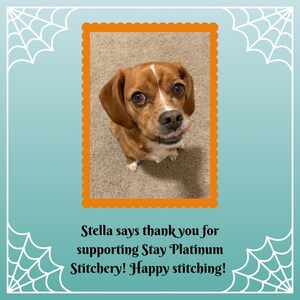 May include: A brown and white dog with floppy ears and a white stripe on its head, framed in an orange scalloped border. The image is set against a teal background with white spiderweb designs and text that reads, "Stella says thank you for supporting Stay Platinum Stitchery! Happy stitching!"