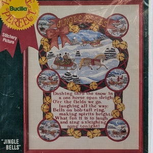 May include: A Bucilla "Jingle Bells" stitchery picture kit. The kit includes silk screened fabric, cotton floss, rayon thread, and decorative trimmings. The design features a winter scene with a horse-drawn sleigh and the text "Jingle Bells". The kit measures 14 x 18 inches.