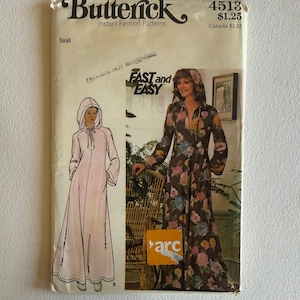 May include: A Butterick 4513 sewing pattern envelope for a hooded robe in size small. The cover features illustrations and photographs of a long-sleeved, floor-length hooded robe with a front tie closure, shown in both solid light pink and a dark brown floral print.