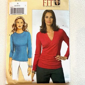 May include: A sewing pattern titled "V8151" with illustrations of two tops. The pattern includes the text "TODAY'S FIT BY SANDRA BETZINA". The illustration on the left shows a blue top, and the illustration on the right shows a red top.