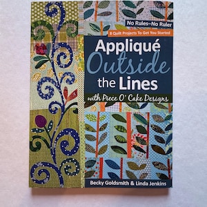 May include: A book cover titled "Appliqué Outside the Lines" with colorful patchwork designs. The cover features text that reads "No Rules - No Ruler" and "8 Quilt Projects To Get You Started". The book is by Becky Goldsmith & Linda Jenkins.
