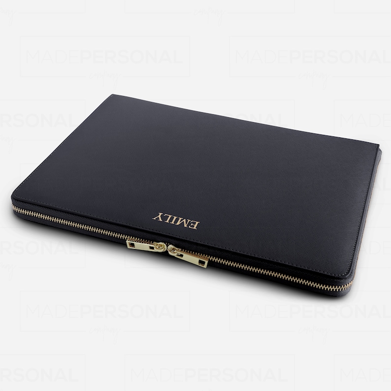 May include: A black rectangular laptop sleeve with a textured finish, featuring a gold-toned metal zip closure and the name EMILY embossed in gold lettering on the front surface. The sleeve has a slim profile and a secure zip-around design.