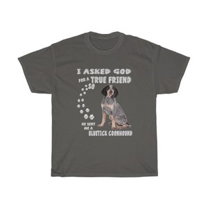 Pode incluir: Uma camiseta cinza escura com texto branco que diz "Eu pedi a Deus um verdadeiro amigo, ent&atilde;o ele me enviou um Bluetick Coonhound". O texto &eacute; cercado por pegadas. Um c&atilde;o Bluetick Coonhound est&aacute; sentado no centro da camiseta.
