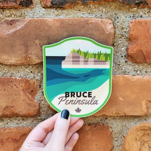 May include: A green, white, and blue sticker with a stylized image of a cliff and water. The text "Bruce Peninsula" is written in brown lettering on the sticker.