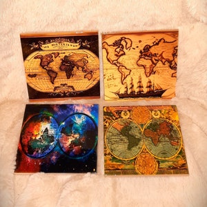May include: Four square coasters with different world map designs. One coaster features a vintage world map with a ship sailing on the ocean. Another coaster has a colorful, abstract world map with a galaxy background. The third coaster has a vintage world map with a compass design. The fourth coaster has a vintage world map with a ship sailing on the ocean.