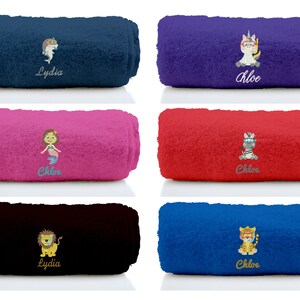 K&ouml;nnte beinhalten: Sechs aufgerollte Handt&uuml;cher in verschiedenen Farben mit gestickten Designs. Die Handt&uuml;cher zeigen eine Meerjungfrau, ein Einhorn, ein Zebra, einen L&ouml;wen, einen Hai und einen Tiger. Die Handt&uuml;cher sind mit den Namen "Chloe" und "Lydia" personalisiert.