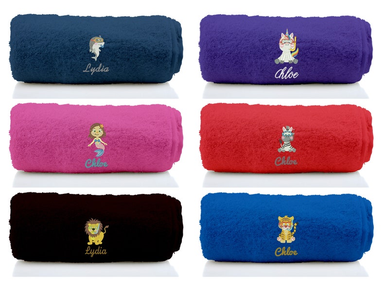 K&ouml;nnte beinhalten: Sechs aufgerollte Handt&uuml;cher in verschiedenen Farben mit gestickten Designs. Die Handt&uuml;cher zeigen eine Meerjungfrau, ein Einhorn, ein Zebra, einen L&ouml;wen, einen Hai und einen Tiger. Die Handt&uuml;cher sind mit den Namen "Chloe" und "Lydia" personalisiert.