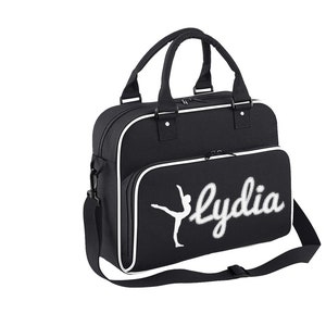 May include: Black canvas gym bag with a white trim and a white silhouette of a dancer with the name "Lydia" embroidered in white.