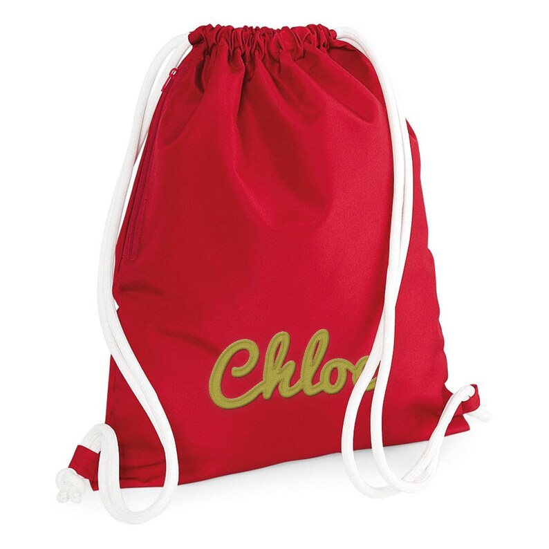Puede incluir: Mochila de cord&oacute;n roja con cordones blancos y un nombre bordado en oro "Chloe" en la parte delantera.