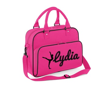 May include: Pink canvas dance bag with a black silhouette of a dancer and the name "Lydia" embroidered on the front.