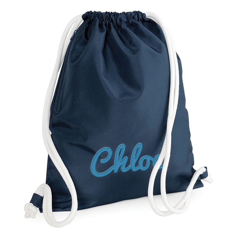 Puede incluir: Una bolsa de cord&oacute;n azul marino con cordones blancos y un nombre bordado en azul "Chloe" en la parte delantera.