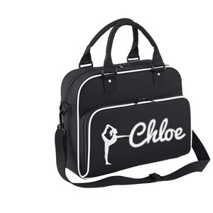 May include: Black gym bag with a white trim and a white embroidered gymnast silhouette and the name "Chloe".