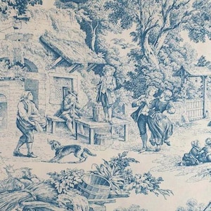 Op de afbeelding: Blauw en wit toile de Jouy stof met een gedetailleerde pastorale scène. De illustratie toont figuren in historische kleding, gebouwen en bomen. Het ontwerp bevat een hond en geiten.