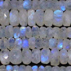 May include: A strand of white moonstone beads with iridescent blue and green flashes. The beads are smooth and polished, and they are arranged in a row.