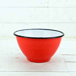 May include: A red enamel mixing bowl with a white interior and a black rim.