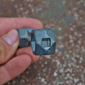 K&ouml;nnte beinhalten: Nahaufnahme eines silbernen Schraubenschl&uuml;ssels mit quadratischem Kopf und einem diamantf&ouml;rmigen Loch in der Mitte.