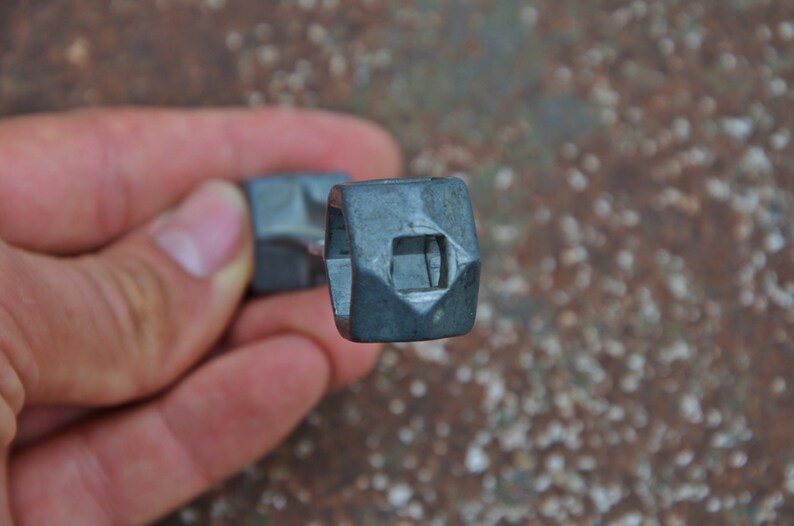 K&ouml;nnte beinhalten: Nahaufnahme eines silbernen Schraubenschl&uuml;ssels mit quadratischem Kopf und einem diamantf&ouml;rmigen Loch in der Mitte.