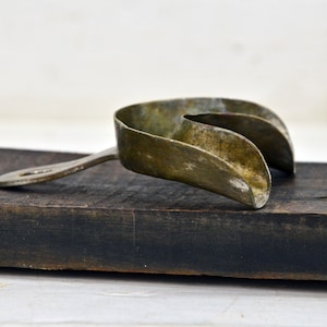 Può includere: Un bavaglio per bocca in metallo vintage con un manico. Il bavaglio è fatto di un metallo sottile e ha un aspetto usurato e invecchiato.
