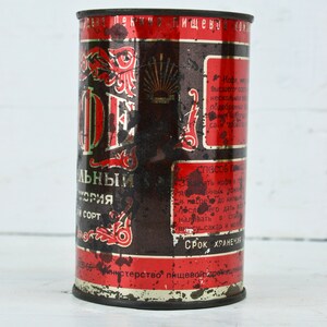 May include: A vintage metal can of coffee with red and black lettering. The can is labeled "Кофе" and "Высшего сорта".
