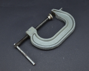 May include: A gray metal C-clamp with a threaded screw and a handle. The clamp is labeled "91-60W MADE IN USA".