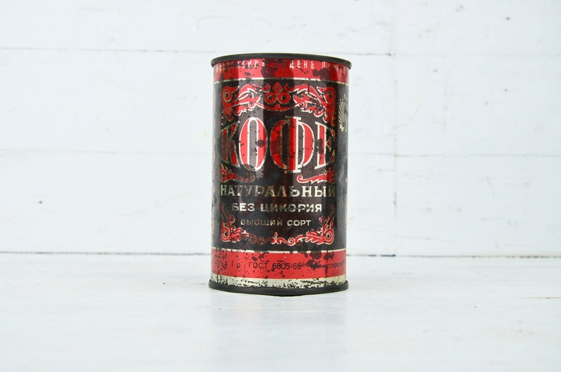 May include: A vintage metal can of coffee with red and black lettering. The can reads "Кофе" and "натуральный без цикория высший сорт".