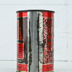 May include: A vintage metal tin with red and black lettering and a decorative design. The tin is labeled "Вес 125" and has text in Russian.